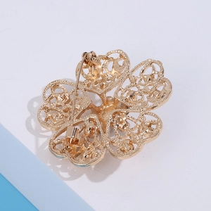Detail showing the metal alloy flower brooch back with a secure long pin fastener