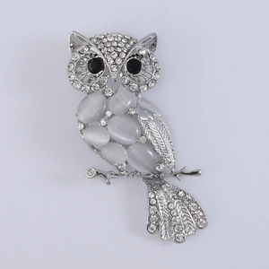 Detail of owl brooch with opal stones and crystals on a silver-tone metal base