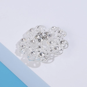 Detailed close-up of hollow filigree flower brooch with sparkling clear crystals