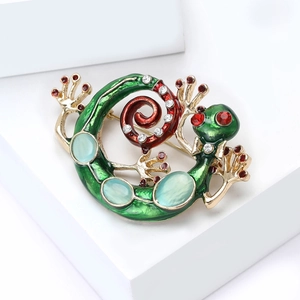 Detailed macro of green lizard brooch with cat-eye stones and red crystal eyes
