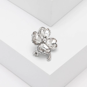 Detailed view of silver four-leaf clover brooch with sparkling heart-shaped crystals