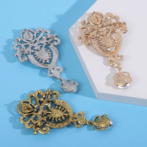 Vista detallada del revés de broches vintage con pedrería en acabados plata, oro y bronce