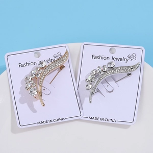 Elegant curved plant brooches with rhinestones in gold and silver set on a display card
