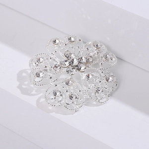 Close-up of rhinestone flower brooch with intricate hollow metal mesh design