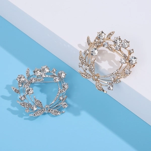 Elegante bloemenkrans broches met strass steentjes in goud en zilver op blauw