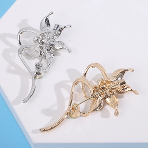 Detail showing the rotating pin fastener and metal craftsmanship of flower brooches