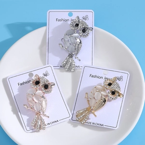 Detailed view of three owl brooches with cat eye stones and sparkling rhinestones