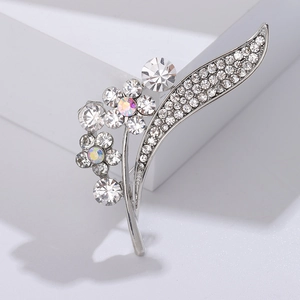 Macro detail of elegant floral brooch with sparkling rhinestones and silver leaves