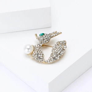 Détail d'une broche renard en strass avec perle blanche sur des blocs géométriques