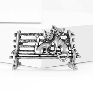 Broche chat vintage sur banc en argent vieilli sur socle blanc minimaliste