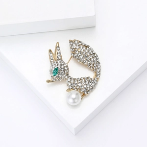 Vue détaillée de la broche renard avec strass, œil en gemme verte et grande perle blanche