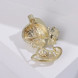 Detail of the golden brooch back featuring a secure vertical pin and cylindrical clasp