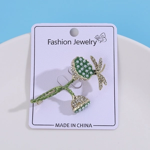 Elegant gold lotus brooch with green enamel dragonfly and white faux pearls in a ceramic tray
