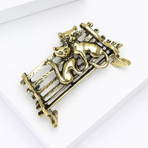 Détail d'une broche chat vintage en alliage doré avec deux chats sur un banc