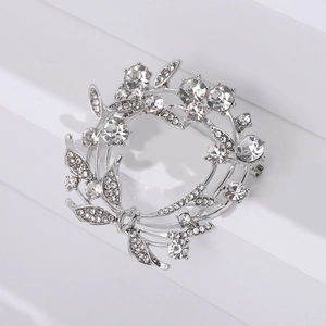 Close-up van fonkelende strass krans broche in zilver op minimalistische witte treden