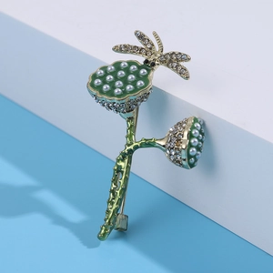 Macro detail of lotus seed pod brooch with green enamel, pearls and crystals