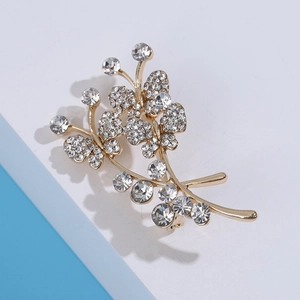 Détail de la broche bouquet papillon dorée ornée de zircons blancs étincelants