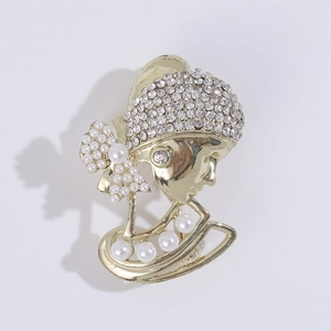 Detail of vintage lady silhouette brooch with gold alloy, rhinestones and white pearls