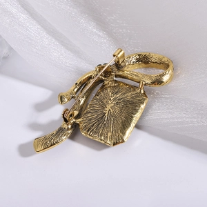 Macro view showing back detail of vintage gold alloy brooch with pin closure and brushed texture