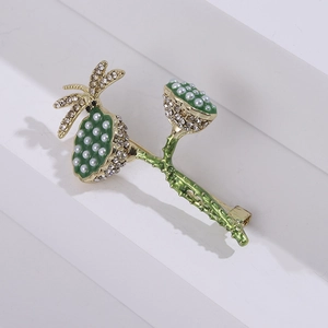 Detail view of lotus and dragonfly brooch with green enamel and sparkling rhinestones