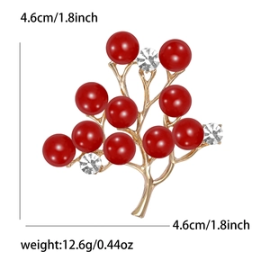 Détail d'une broche branche dorée avec perles rouges et cristaux, taille 4,6cm