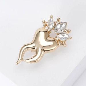 Detailed view of a gold heart crown brooch with clear gemstones on a white pedestal