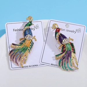 Vintage peacock feather brooches with colorful enamel coating and sparkling rhinestones