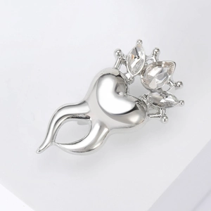 Macro detail of silver crown-shaped tooth brooch with sparkling rhinestone crystals