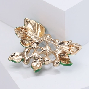 Detail view of the plant brooch back with a golden safety pin and rotating clasp mechanism