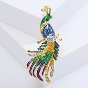 Macro detail of luxury peacock brooch with green enamel and sparkling rhinestones
