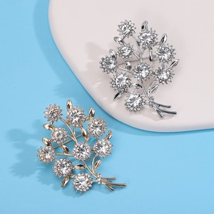 Détail de broches en forme de bouquet avec micro-pavage de cristaux dorés et argentés