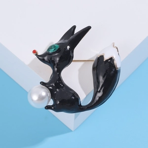 Détail de la broche renard en émail noir avec œil en gemme verte et perle blanche