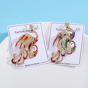 Vintage gold peacock brooches with colorful enamel wings and sparkling rhinestones