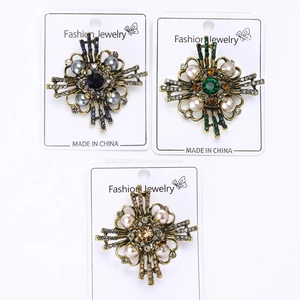 Close-up of vintage baroque brooches with pearls and colorful crystals on gold base