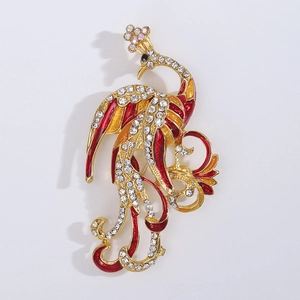 Macro detail of a golden phoenix brooch with red enamel wings and sparkling rhinestones