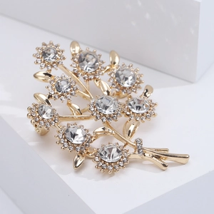 Vue macro d'une broche bouquet dorée avec des strass étincelants et un sertissage à griffes fin