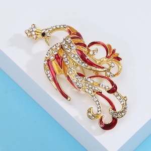 Exquisite gold-plated phoenix brooch with red enamel wings and sparkling rhinestones