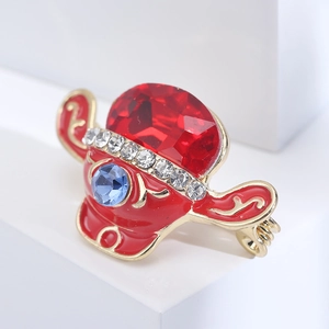 Close-up of red enamel hat brooch with crystal inlay and anime inspired design