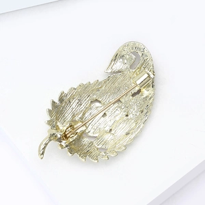 Detailed back view of golden leaf brooch showing brushed texture and safety pin clasp