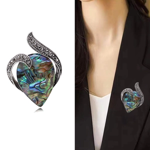 Detailed view of teardrop abalone shell brooch with marquise stones and model display