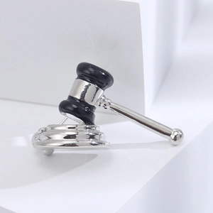 Detailed macro view of silver alloy gavel brooch with black enamel inlay and polished finish
