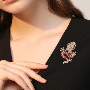 Exquisite gold dragon brooch with red rhinestones on a stylish black knit sweater