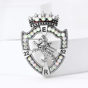 Vintage silver lion shield brooch with crown and colorful rhinestones on white display
