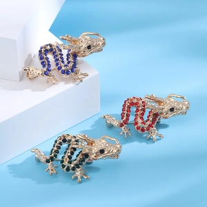 Detail of dragon brooches with inlaid crystals in red, blue, and green on gold base