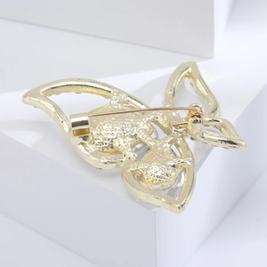 Detailed back view of a golden butterfly brooch featuring a pin fastener and honeycomb texture