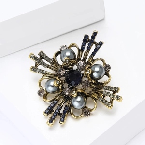 Detail of vintage Baroque brooch with blue gemstone and pearls on white block