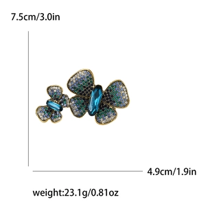 Detailed size view of a golden butterfly brooch with blue rhinestones and gems