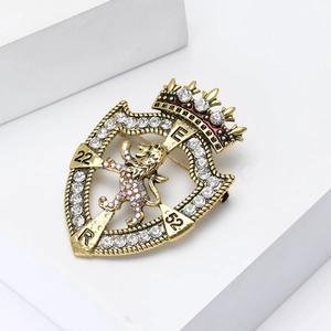Vintage gold lion shield brooch with white rhinestones and crown detail on stone