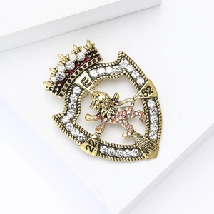Macro shot of retro lion shield brooch with crystal inlay and gold finish crown detail