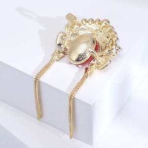 Detailed back view of a Chinese opera style brooch with gold tassels and pin clasp